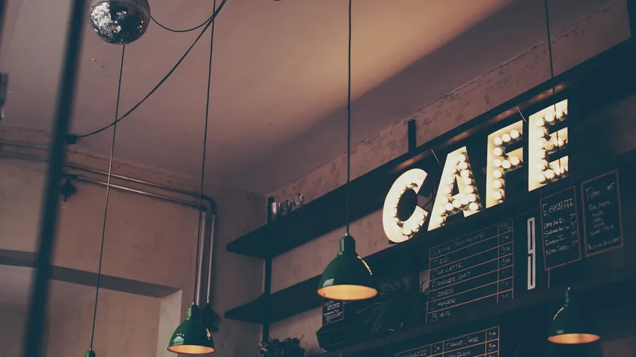 Coffee shop customer using loyalty app to earn rewards on phone